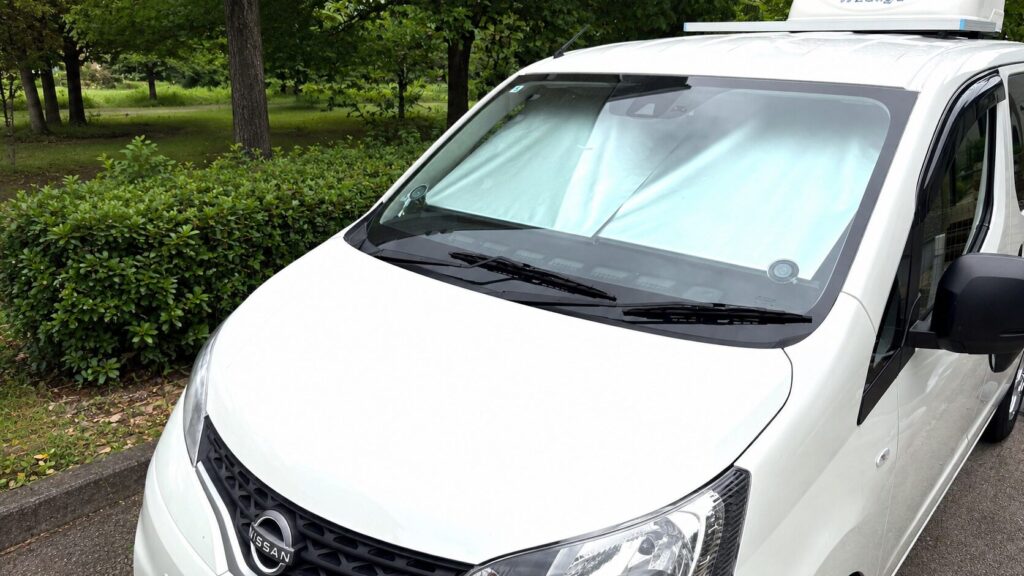 NV200バネットベースのキャンピングカーのフロントガラスに設置したロール式サンシェード（車外から）