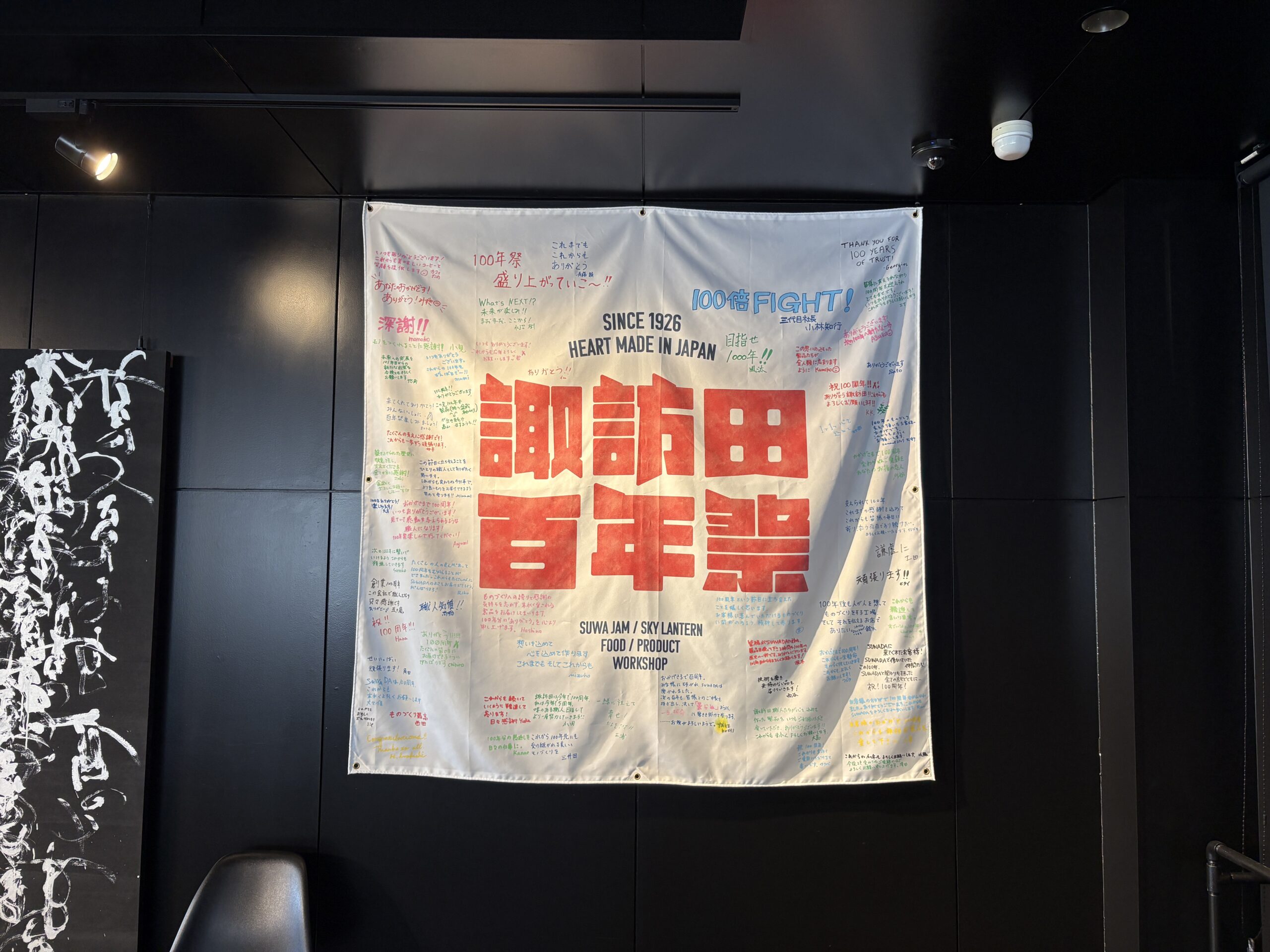 諏訪田製作所の館内に飾られた諏訪田百年祭の寄せ書き旗