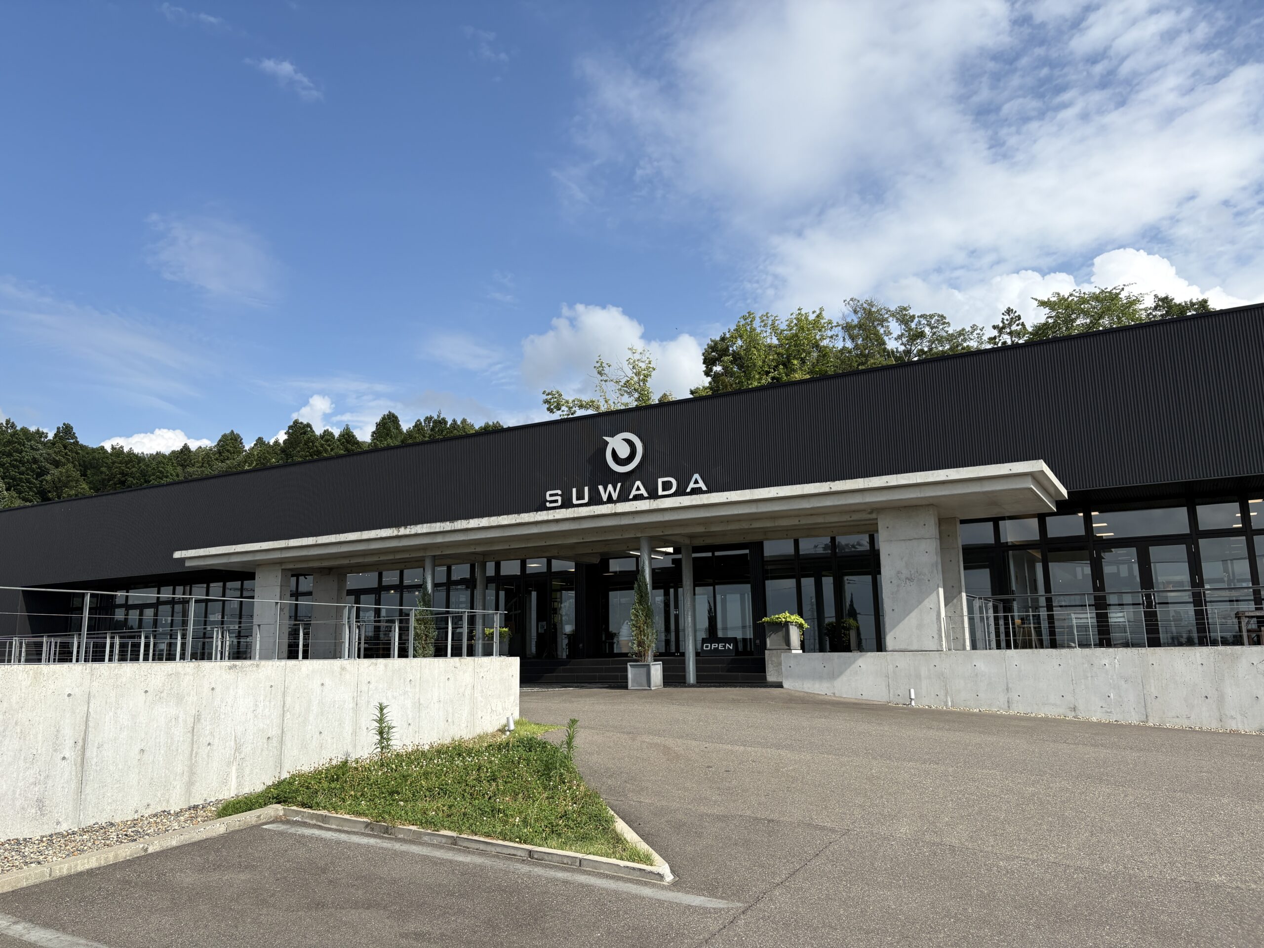 駐車場から見た諏訪田製作所 SUWADA OPEN FACTORY の建物正面